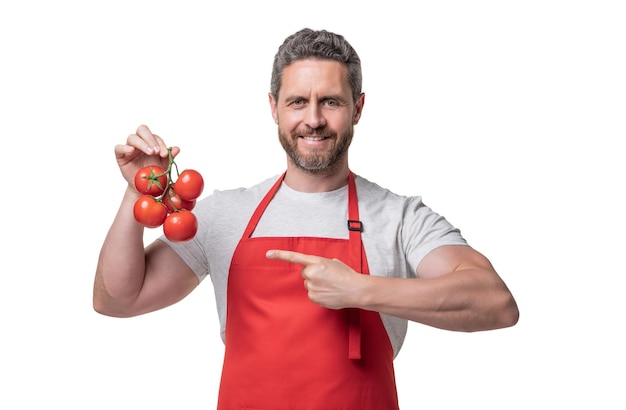 Homme en tablier avec légume tomate isolé sur un doigt pointu blanc