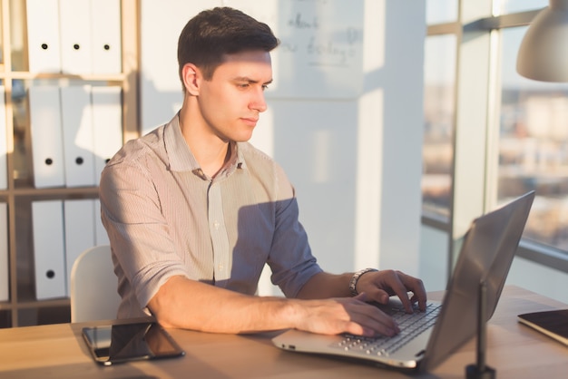 Homme taper du texte ou un blog au bureau, son lieu de travail, à l'aide du clavier pc. Homme d'affaires travaillant.