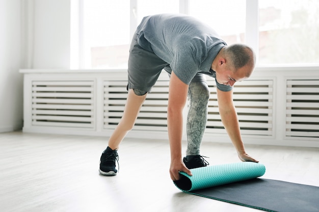 Homme avec tapis d'exercice