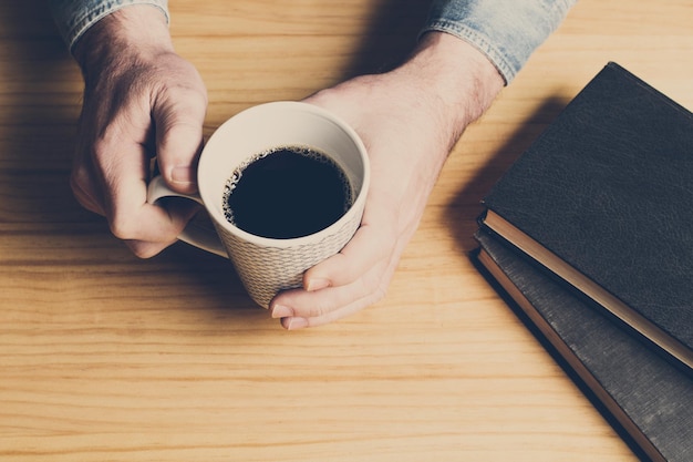 Un homme avec une tasse de café sur une table