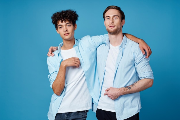 Photo homme avec tatouage embrasse son ami sur fond bleu et vue coupée amusante photo de haute qualité