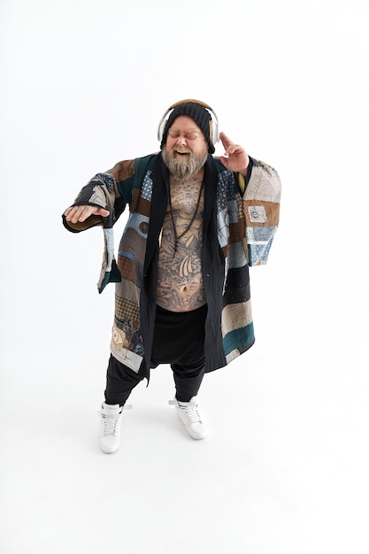 Homme tatoué barbu élégant en surpoids avec gros ventre pose et danse en kimono