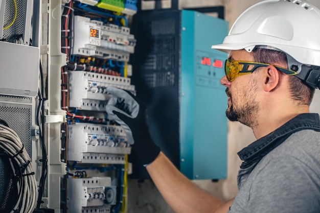 Homme un technicien électricien travaillant dans un standard avec des fusibles