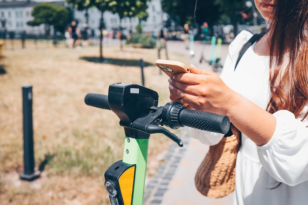 Un homme avec un téléphone dans les mains utilise une application pour un scooter électrique