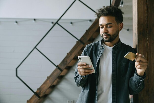 Photo un homme avec un téléphone portable et une carte de crédit