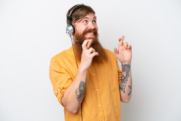 Homme de télévendeur isolé sur fond blanc avec les doigts croisés