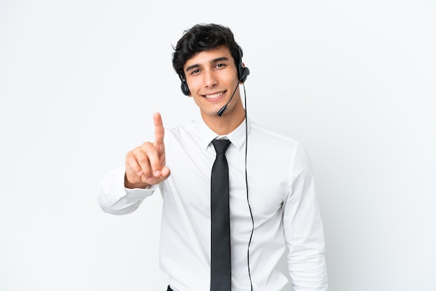 Homme de télévendeur travaillant avec un casque isolé sur fond blanc montrant et levant un doigt