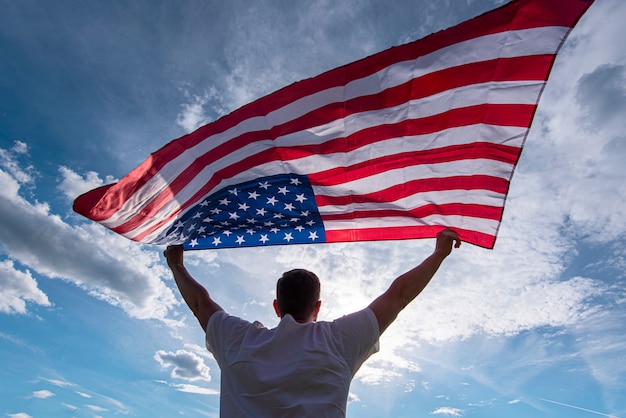 Homme tenant en agitant le drapeau américain USA dans les mains aux USA, photo concept
