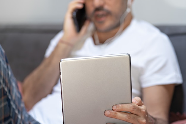 Homme tenant à l'aide de l'appel vidéo smartphone tablette numérique.