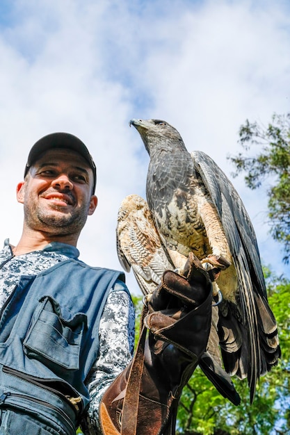 Homme tenant un aigle à poitrine noire