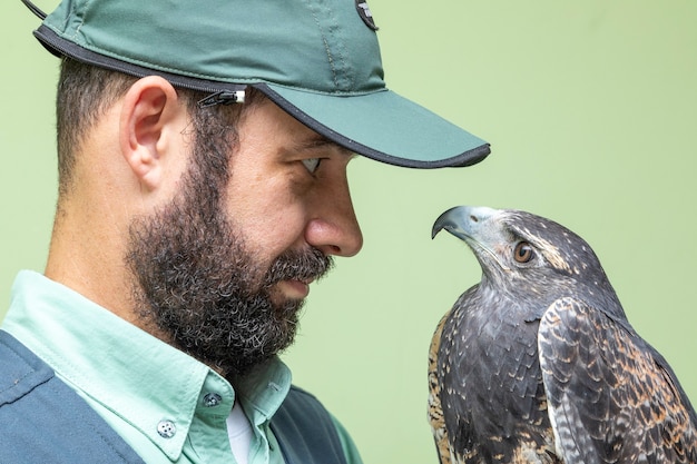 Homme tenant un aigle à poitrine noire