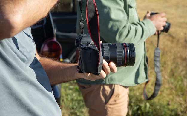 Homme tenant un appareil photo reflex numérique en plein air