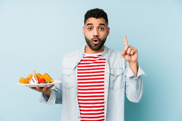 Homme tenant une assiette avec des gaufres