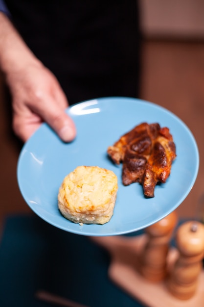 Homme Tenant Une Assiette Avec De La Nourriture Pour Un Anniversaire Romantique Avec Sa Femme Dans La Cuisine Homme à La Retraite Dans La Cuisine Avec