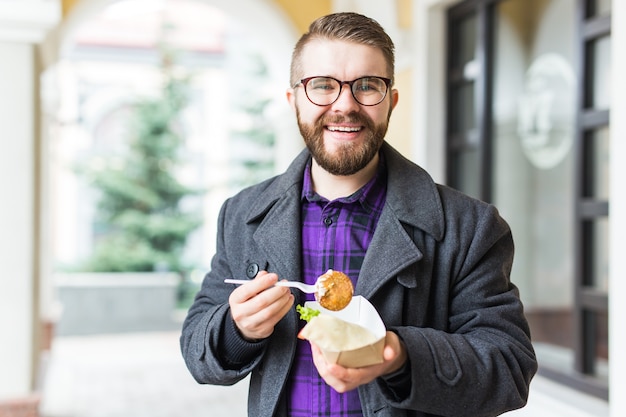 Homme tenant une assiette unique avec un délicieux falafel de cuisine juive traditionnelle à base de pois chiches au festival de la cuisine de rue. Repas végétarien frit très savoureux.