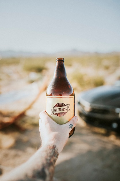 Homme tenant une bière froide