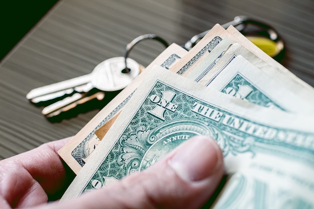 Un homme tenant un billet d'un dollar américain en photo en gros plan avec des touches en composition