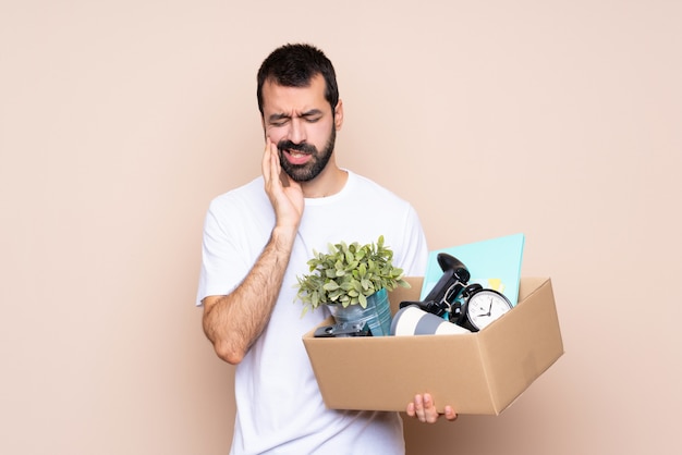 Homme tenant une boîte et emménager dans une nouvelle maison avec maux de dents