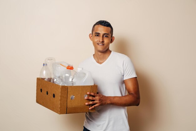 Homme tenant une boîte de papier avec une bouteille en plastique Détritus à recycler