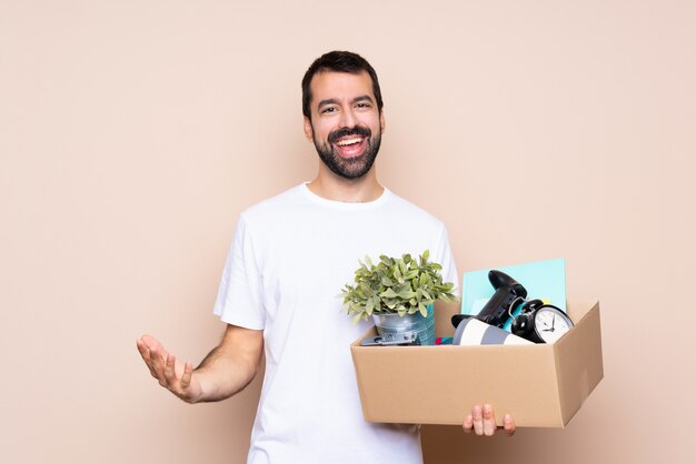 Homme tenant une boîte et se déplaçant dans la nouvelle maison sur fond isolé souriant