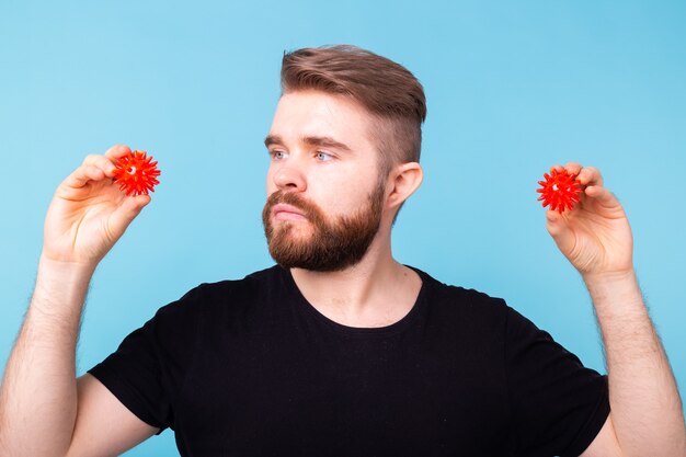 Homme tenant des boules de Covid rouges