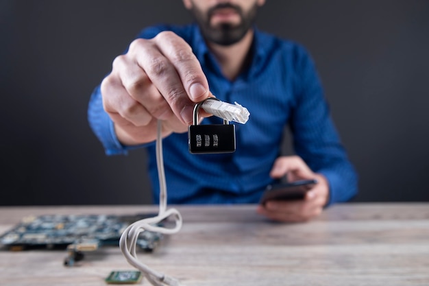 Homme tenant le câble de verrouillage et de technologie sur la table