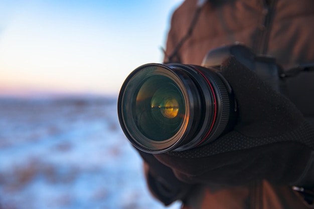 Homme tenant une caméra dans la nature hivernale