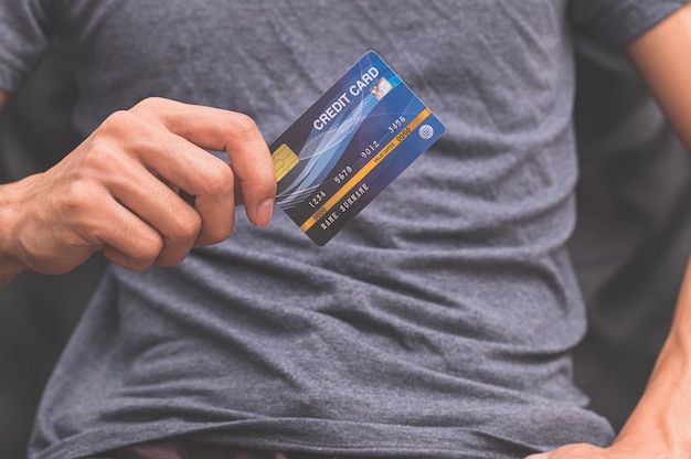 Un homme tenant une carte de crédit sur sa main