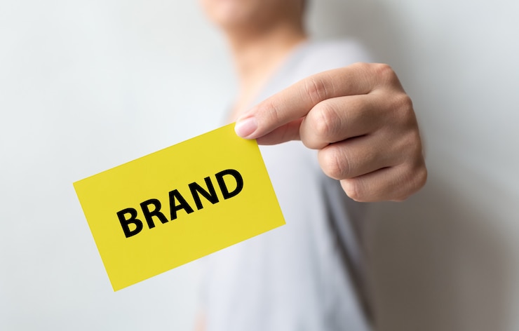 Photo homme tenant une carte jaune et mot marque. renforcement de la marque pour le concept de réussite