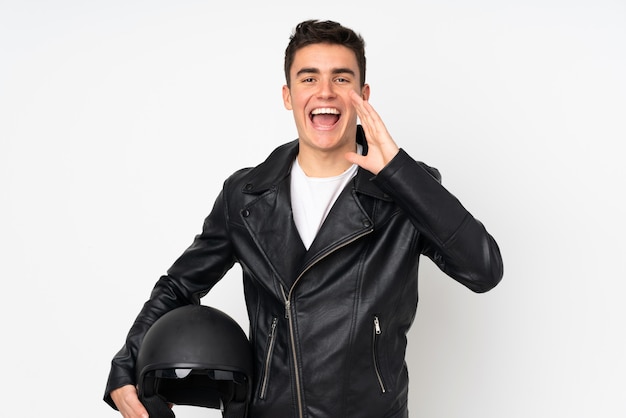 Homme tenant un casque de moto sur un mur blanc criant avec la bouche grande ouverte