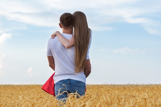 Homme tenant doucement sa bien-aimée dans le champ de blé. Des moments romantiques
