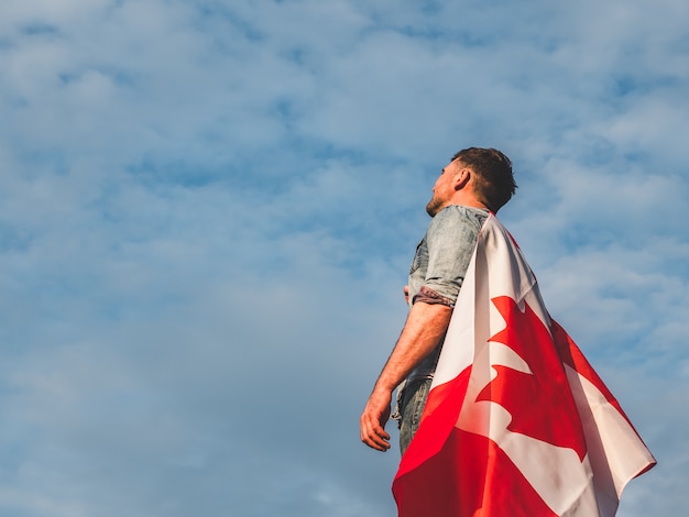 Homme tenant un drapeau canadien