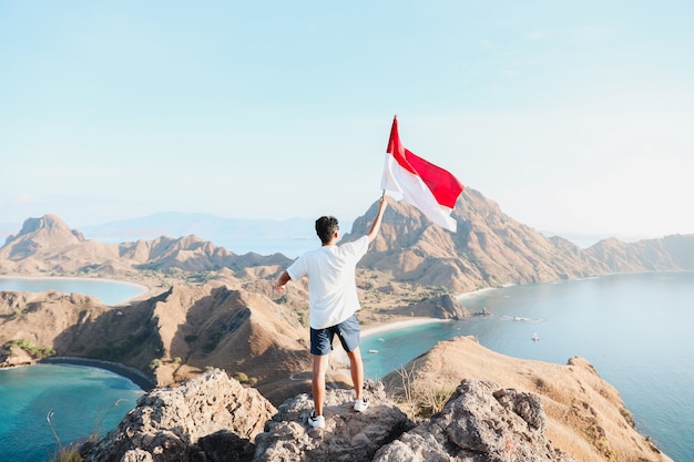 Un homme tenant un drapeau indonésien à Labuan Bajo