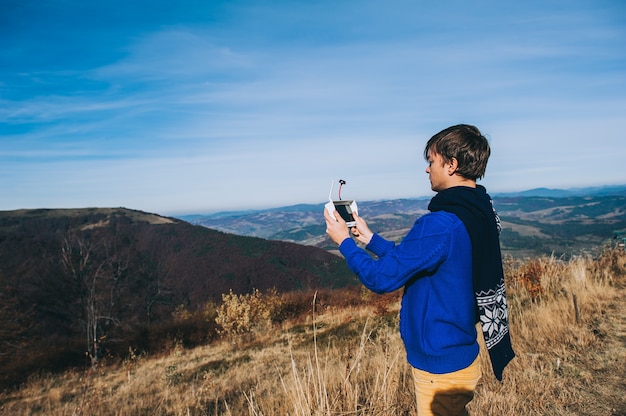 homme tenant un drone pour la photographie aérienne. silhouette contre le ciel coucher de soleil