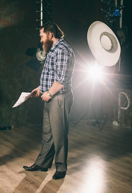 Photo homme tenant du papier alors qu'il se tient dans une pièce éclairée