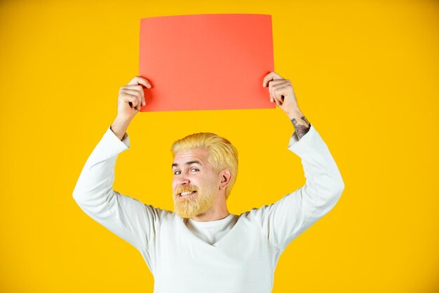 Homme Tenant Une Feuille De Papier Vierge Isolée Sur Fond Jaune