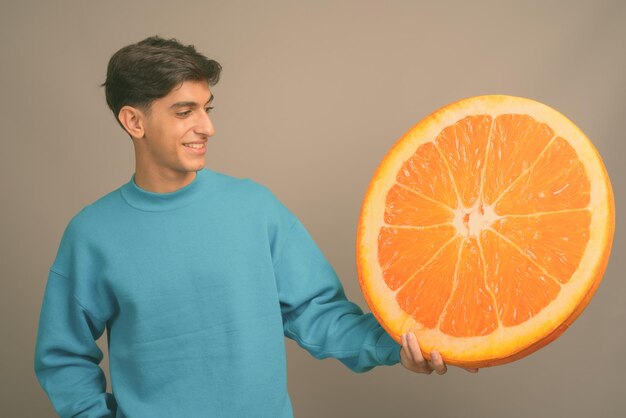 Photo un homme tenant un fruit d'orange