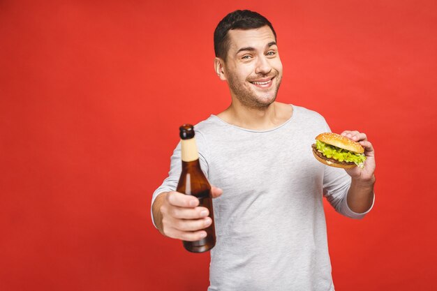 Homme tenant un hamburger et une bouteille de bière