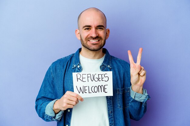 homme tenant une pancarte de bienvenue de réfugiés