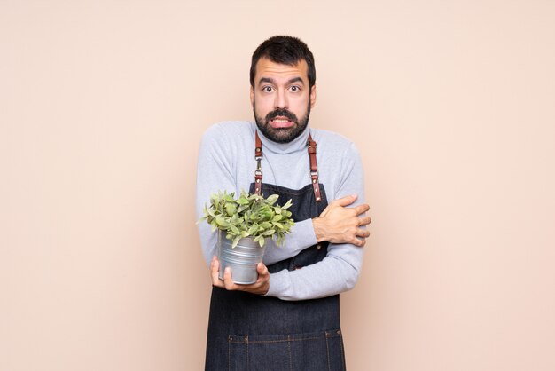 Homme tenant une plante sur la congélation isolée