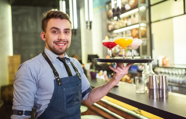 L'homme tenant le plateau avec des cocktails de couleur