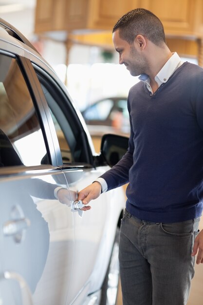 Homme tenant une poignée de voiture