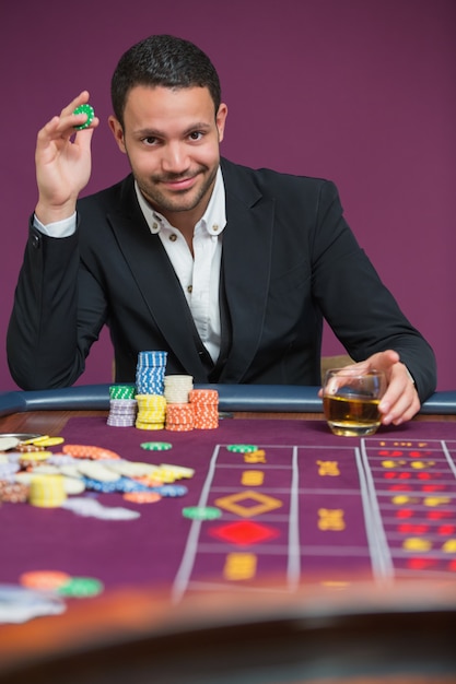 Homme tenant une puce et un verre de whisky