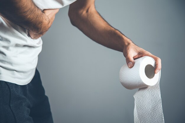 Homme tenant un rouleau de papier toilette