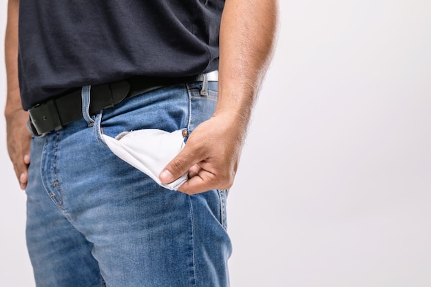 Homme tenant sa poche de pantalon pour ne montrer aucun argent à l'intérieur