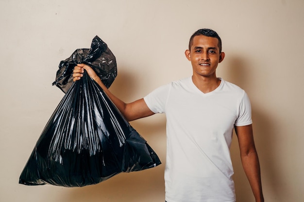 Un homme tenant un sac noir de déchets