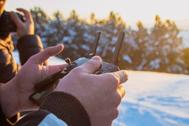 Un homme tenant une télécommande d'un drone en hiver