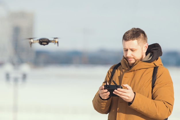 Un homme tenant une télécommande pour le drone gérant le vol du quadricoptère