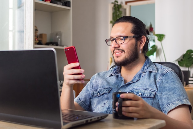 Homme tenant un téléphone et une tasse de café