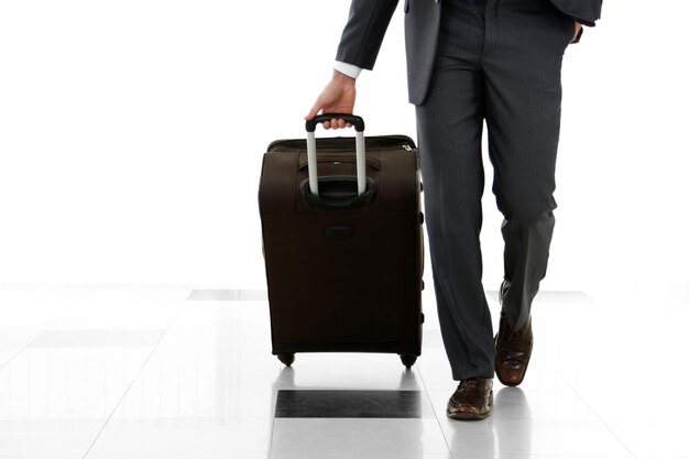 Photo homme tenant une valise sur un fond clair